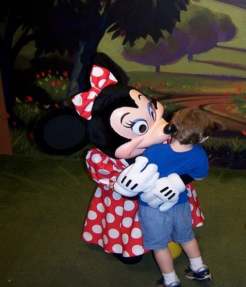 Minnie Mouse Hugs Reluctant Boy